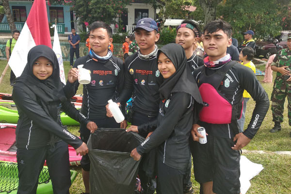 Tim Ekspedisi Kayak Pelajar Indonesia URaL SMAN 28 Jakarta menunjukkan kantong plastik berisikan sampah yang mereka kutip dari perairan Danau Toba.