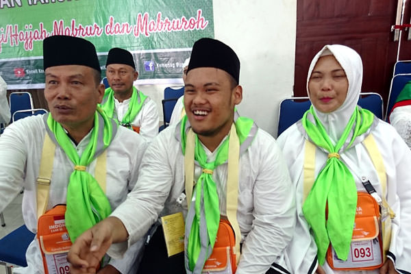 agusman/sumut pos TERMUDA: Habib Suwanda Siregar (tengah) bersama kedua orangtuanya saat antre pemeriksaan kesehatan di Asrama Haji Medan, Kamis (11/7).