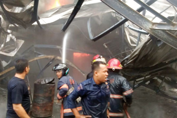 Petugas pemadam kebakaran berupaya memadamkan api yang membakar pabrik springbed milik CV Sahabat Sejati Mandiri/Four Star, l di Dusun IIA, Pasar 5, Desa Helvetia, Labuhandeli, (9/7).