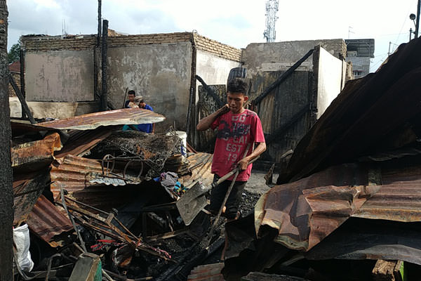 MENGAIS: Korban kebakaran di Jalan Sentosa Lama, Kelurahan Sei Kera Hulu, Kecamatan Medan Perjuangan, mengais sisa-sisa barang dari rumah mereka yang sudah hangus terbakar.