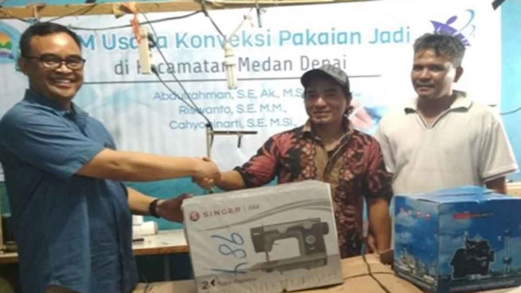 PERALATAN PRODUKSI: 
Dosen Polmed saat memberikan peralatan produksi mesin jahit dan mesin obras untuk mendorong pengembangan usaha konveksi batik di Medan Denai. 