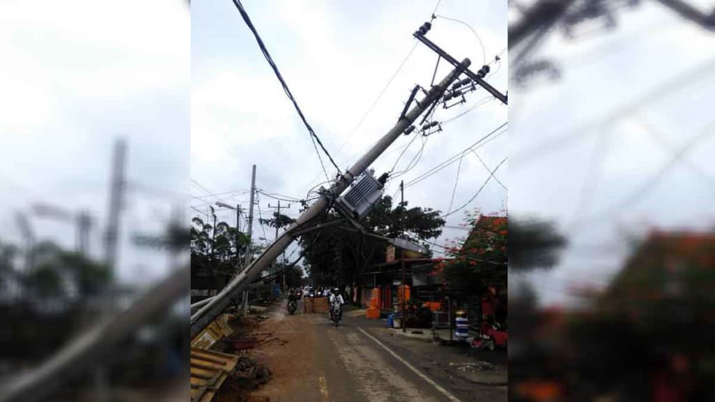 BERBAHAYA: Tiang listrik di Jalan Eka Warni, Medan Johor, nyaris tumbang akibat galian drainase yang dikerjakan Dinas PU Kota Medan. Tiang ini melintang di atas jalan raya sehingga membahayakan pengendara yang melintas di lokasi itu. 
map/sumutpos