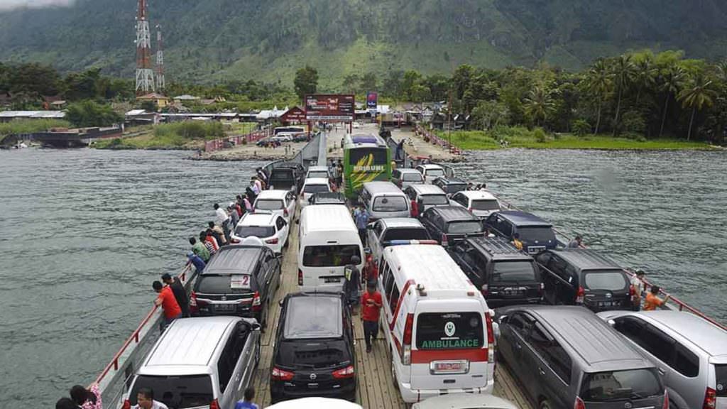 MENYEBERANG: Puluhan mobil berada di atas kapal feri menyeberangi Danau Toba menuju Pulau Samosir.