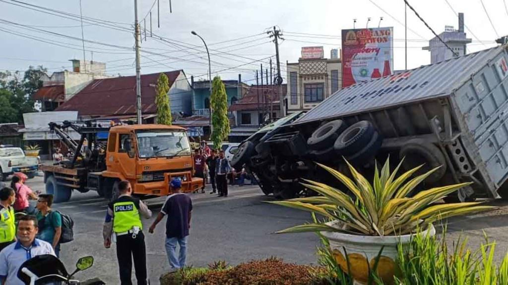 TERBALIK : Truk peti kemas tanpa muatan terbalik dihantam truk fuso di Simpang Empat Cemara Kecamatan Lubukpakam.