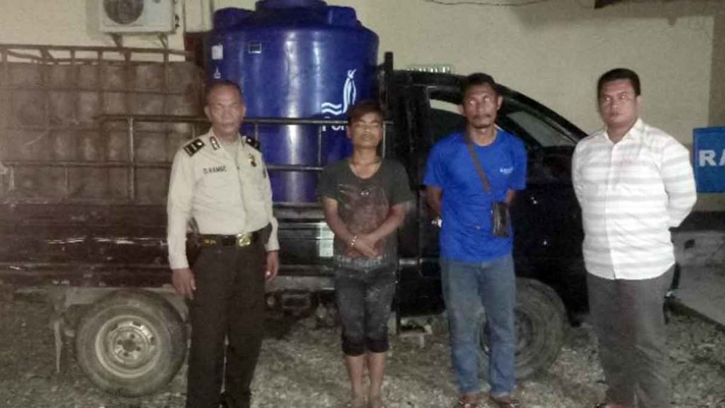 PELAKU: Personel Polres Tanjungbalai mengapit 2 pelaku pembuang limbah cair PT Halindo ke Sungai Asahan, yang diangkut mobil bak terbuka dan dikemas dalam wadah politank kapasitas 1.000 liter.
