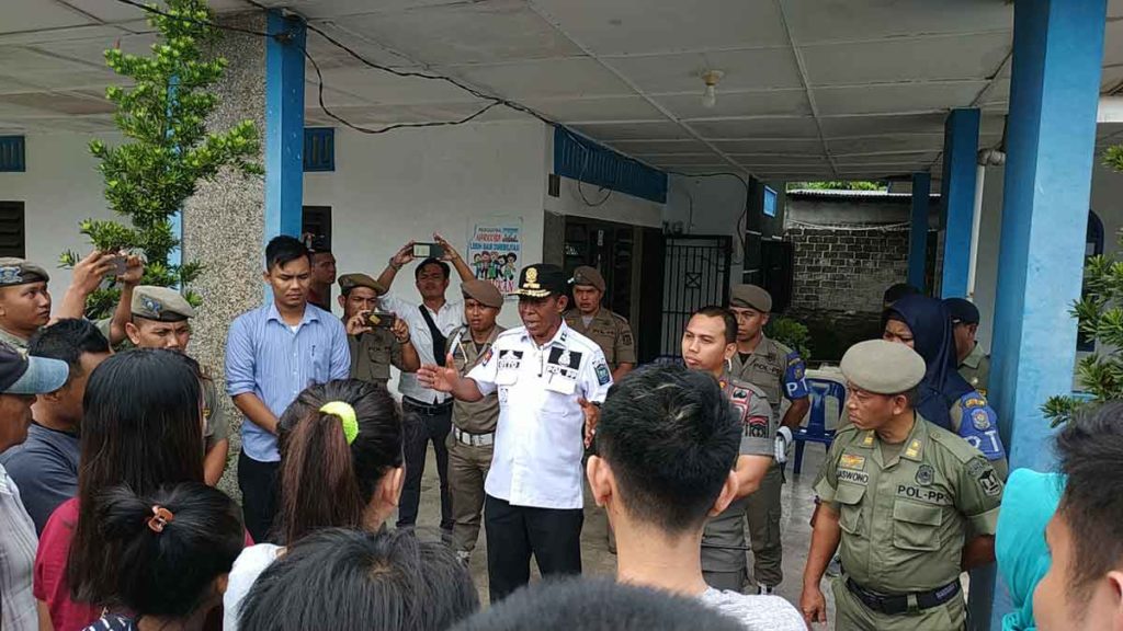 TENANGKAN: Kasatpol PP Binjai Otto Harianto (kemeja putih) menenangkan keluarga yang terjaring operasi pekat.  