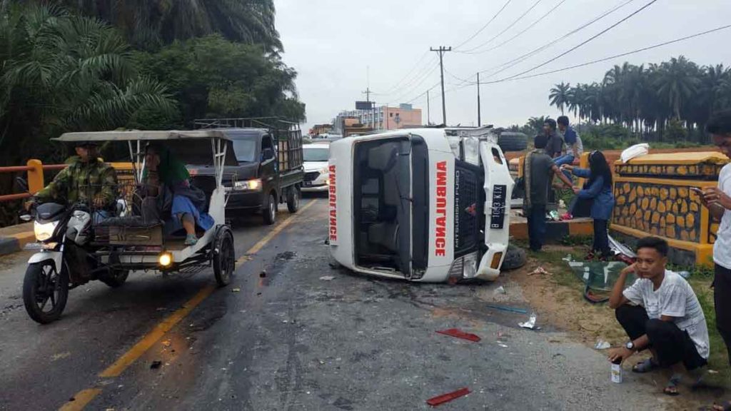 TERBALIK: Akibat ditabrak truk kontainer Fuso BK 9311 DO satu unit kendaran mini bus terbalik. 