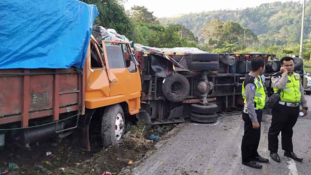 TERBALIK: Truk terbalik  akibat kecelakaan beruntun yang melibatkan tiga kenderaan di Jalan Nasional Sidikalang-Medan tepatnya selepas kota Sumbul Kecamatan Sumbul Dairi. 
RUDY SITANGGANG/SUMUT POS