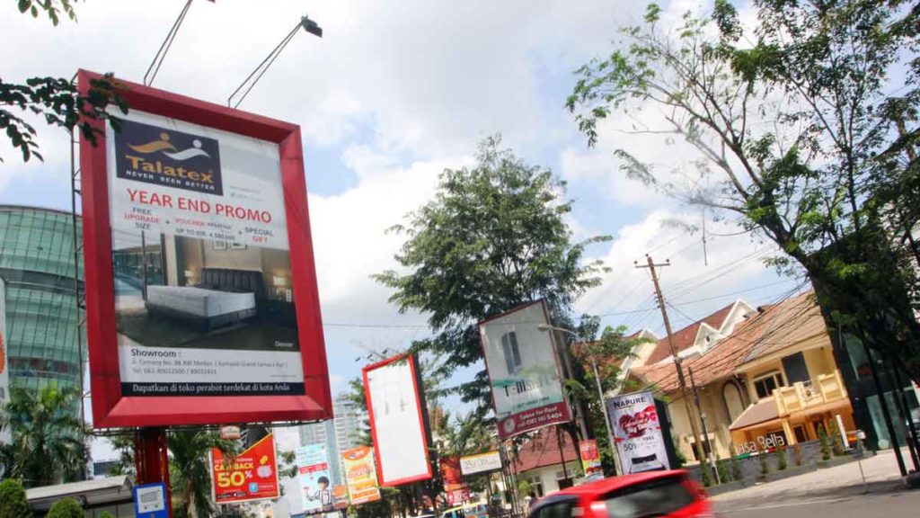 PAPAN REKLAME:
Sejumlah pengendara melintas di samping papan reklame kawasan Kota Medan. Pajak reklame menjadi  penyumbang PAD terendah dengan realisasi 15,78 persen.