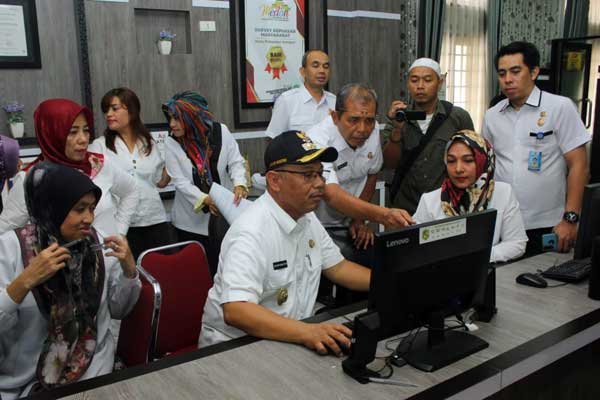 MELIHAT: Plt Wali Kota Medan, Ir H Akhyar Nasution MSi saat melihat daftar perizinan di DPMPTSP Kota Medan, baru-baru ini.