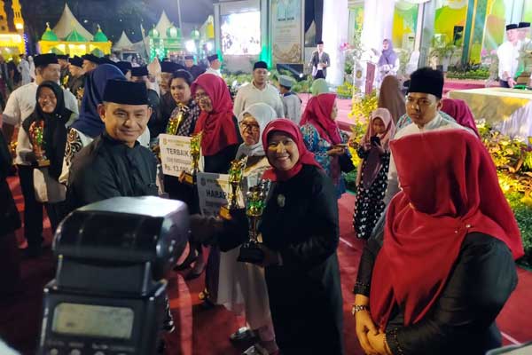 PIALA: Kadis Ketahanan Pangan Kota Medan, Ir Hj Emilia Lubis menerima piala dari Sekda Kota Medan.