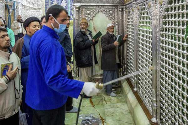 DISINFEKSI: Seorang pekerja mendisinfeksi situs suci Masumeh Qom untuk mencegah penyebaran virus corona di Iran. AFP/FARS NEWS AGENCY/MEHDI MARIZAD
