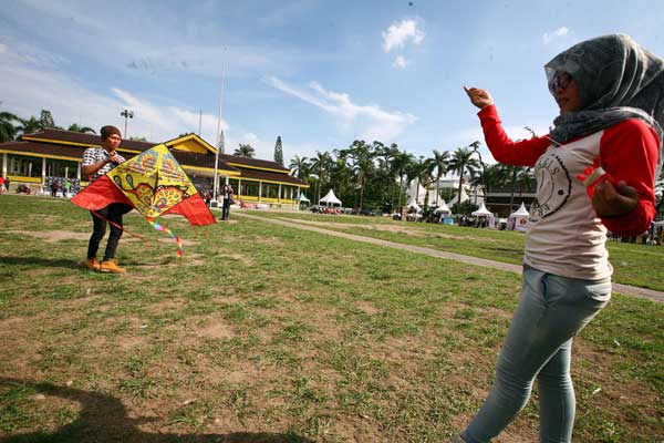 LAPANGAN MERDEKA: Seorang wanita mencoba menerbangkan layangan di Lapangan Merdeka. Pemko Medan berencana merevitalisasi Lapangan Merdeka dengan membangun Pendopo berlantai dua serta menambah sejumlah fasilitas olahraga.