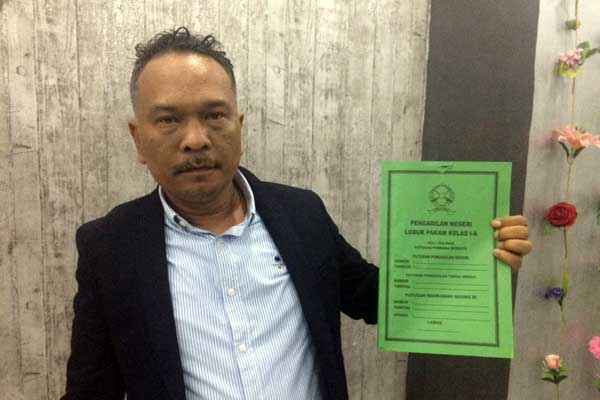 MEMEGANG: Kuasa hukum Tengku Osman Amal, Syahputra Lubis SH memegang salinan putusan Pengadilan Lubukpakam yang memenangkan gugatan pihaknya atas PTPN II.