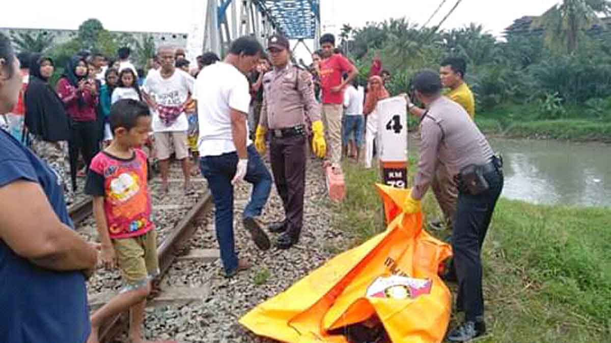 EVAKUASI: Potongan tubuh korban yang tertabrak kereta api dievakuasi petugas kepolisan.