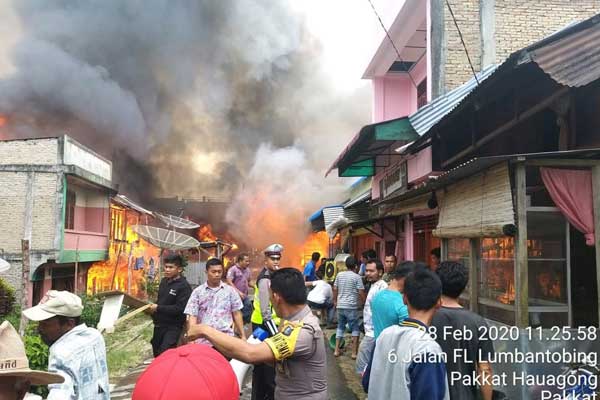 Terbakar: Belasan rumah habis dilalap si jago merah di Jalan Imam Bonjol Desa Pakkat. Polisi, TNI dan warga , tampak berupaya memadamkan saat sebelum unit pemadam kebakaran datang, Jumat (28/2).