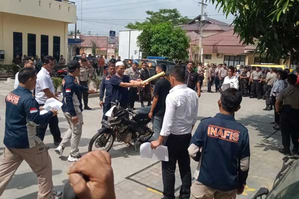 REKONSTRUKSI: Tersangka LI (37) memperagakan adegan saat memukul leher korban dengan potongan kayu.