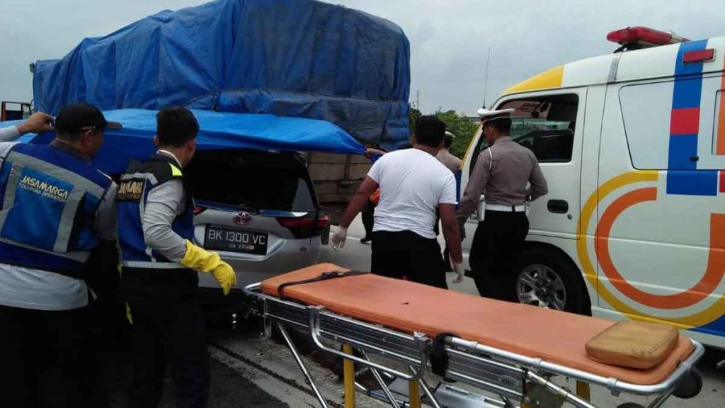 EVAKUASI-Personel Sat Lantas Polresta  Deliserdang mengevakuasi korban kecalakan lalulintas di Jalan Tol  Tebing Tingg- Medan di 37.900. Kecelakaan itu menyebakan satu orang korban tewas dan dua luka-luka, Senin (3/2). agusman/SUMUT POS
