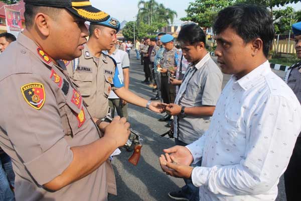 PERIKSA: Wakapolresta Deliserdang, AKBP Julianto P Sirait memeriksa senpi personel di halaman Polresta Delisedang, Jumat (27/2).