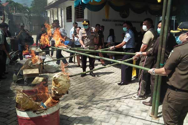 DIBAKAR: Kejari Dairi, Syahrul Juaksha Subuki (kanan) didampingi Kapolres Dairi AKBP Leonardo Simatupang membakar barangbukti sabu dan ganja. Senin (24/2).