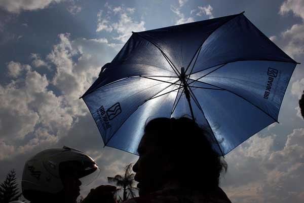 TERIK MATAHARI: Seorang warga menggunakan payung sebagai pelindung dari teriknya panas matahari di Jalan Jamin Ginting Medan, baru-baru ini. Saat ini Kota Medan memasuki musim kemarau hingga Maret mendatang. DANIL SIREGAR/SUMUT POS