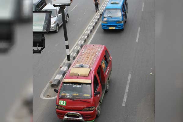 ANGKOT: Angkutan kota (angkot) saat melintas di salah satu ruas jalan di Kota Medan. Jumlah penumpang angkot mengalami penurunan sejak anak sekolah diliburkan.