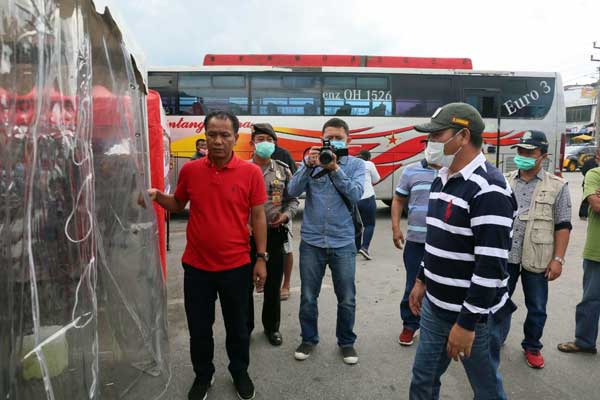 UJI COBA: Bupati Taput, Nikson Nababan menyaksikan para penumpang bus serta sopir yang akan disemprot di bilik dekontaminasi saat uji coba, Rabu (25/3).