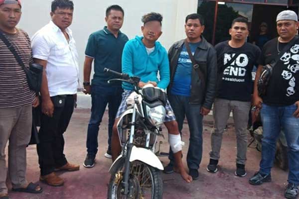 DITEMBAK:Andri Surbakti (20) duduk di atas sepedamotor hasil curiannya.