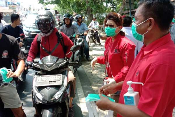 BAGI MASKER: Ketua DPC PDIP Sergai,  H Darma Wijaya bersama pengurus membagikan masker kepengguna jalan, di Jalinsum Sergai, Desa Firdaus, Kecamatan Sei Rampah, Selasa (24/3).