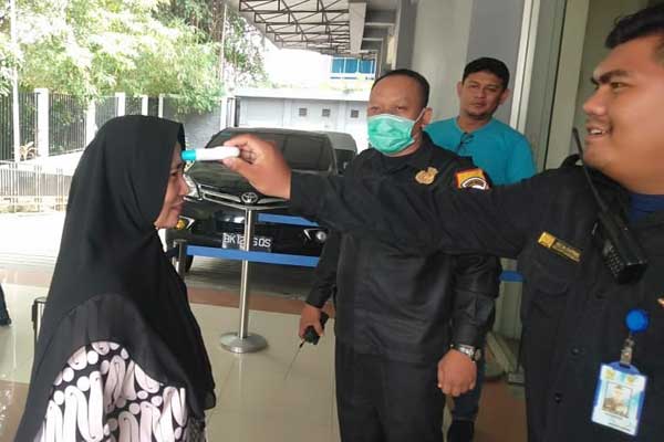 PERIKSA:Security DPRD Medan melakukan pemeriksaan suhu udara terhadap anggota DPRD Medan hingga tamu, di pintu masuk geudng DPRD Medan. markus/sumut pos