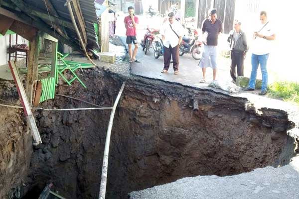 AMBLAS: Camat Sibolangit, Febri Gurusinga, mengecek badan jalan kabupaten di Dusun III, Desa Bandar Baru, Kecamatan Sibolangit, amblas akibat intensitas curah hujan yang tinggi. Terlihat Camat Sibolangit Febri Gurusinga meninjau lokasi, Rabu (11/3). batara/sumut pos