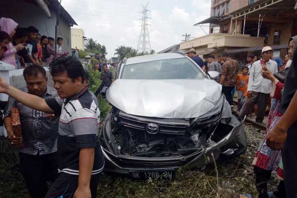 RINGSEK: Mobil Totoya Rush BK 1268 OW yang dikendarai Hamzaruddin tampak ringsek usai ditabrak kereta api di perlintasan tanpa plang, di Jalan Ikan Kakap, Minggu (8/3). teddy/sumu tpos