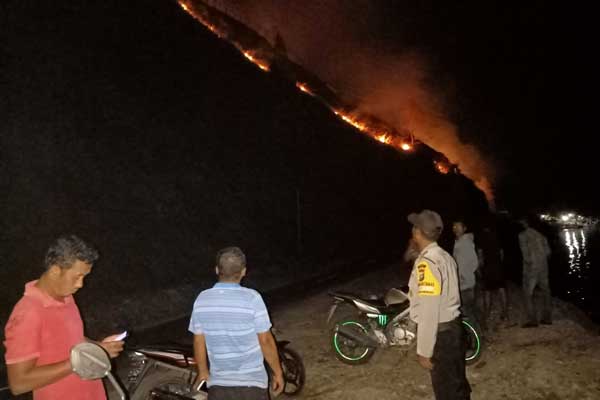 KARHUTLA: Sejumlah warga sedang melihat Kawasan hutan semak belukar di perbukitan Danau Toba di Silalahi Dairi yang terbakar. RUDY SITANGGANG/SUMUT POS