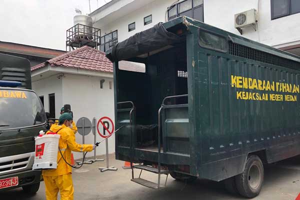 SEMPROT: Mobil tahanan Kejari Medan disemprot cairan disinfektan untuk mencegah covid-19, Selasa (24/3).