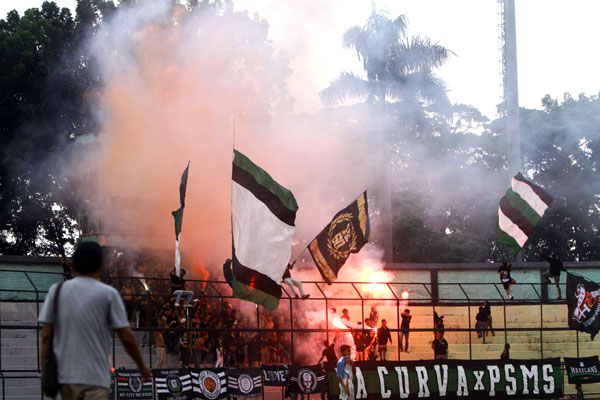 FLARE: Sejumlah supporter PSMS Medan menyalakan flare pada laga kontra Tiga Naga di Stadion Teladan Medan, Minggu (15/3).