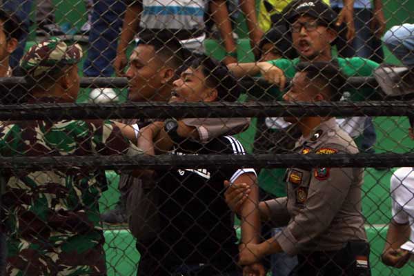 DITANGKAP: Polisi menangkap suporter yang menyalakan flare saat pertandingan PSMS melawan Tiga Naga. triadi wibowo/sumut pos