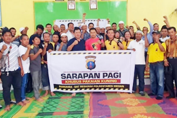 BERSAMA: Personel Polrestabes Medan foto bersama petugas pakaian kuning di Kantor Camat Medan Kota.