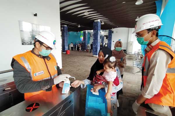 ANTISIPASI CORONA: Petugas menyemprotkan hand sanitizer kepada penumpang di Terminal Penumpang Bandar Deli Pelabuhan Belawan untuk mencegah penyebaran virus corona.