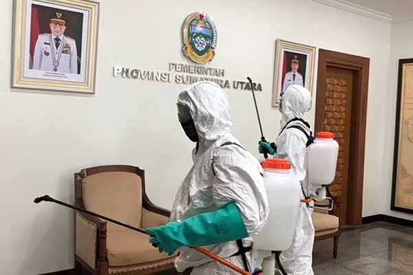 SEMPROT: Petugas dari PMI Kota Medan menyemprotkan disinfektan ruangan di kantor Gubernur Sumut, Rabu (18/3).