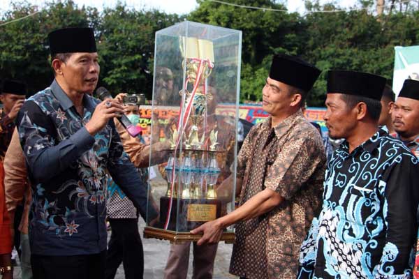 PIALA: Sekda Dairi, Leonardus Sihotang (kiri) memberikan piala kepada Camat Tanah Pinem, Sion Sembiring sebagai juara 1 MTQ tingkat Kabupaten Dairi tahun 2020. RUDY SITANGGANG/SUMUT POS