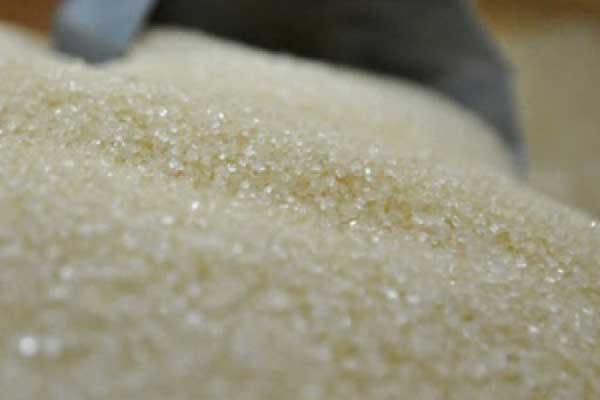 TUANG: Pedagang saat menuangkan gula pasir ke plastik untuk dipasarkan secara kiloan.