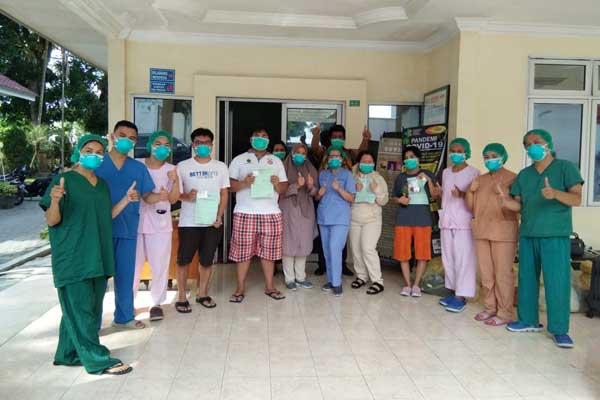 SEMBUH Paramedis RSUP Haji Adam Malik berfoto bersama para pasien yang telah sembuh dari infeksi Covid-19, sebelum mereka dipulangkan, Selasa (7/4).