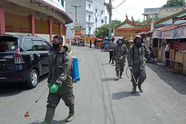 SEMPROT: Petugas Detasemen B Brimob Kota Tebingtinggi melakukan penyemprotan disinfektan  di jalan protokol dan rumah ibadah, Rabu (29/4). SOPIAN/SUMUT POS