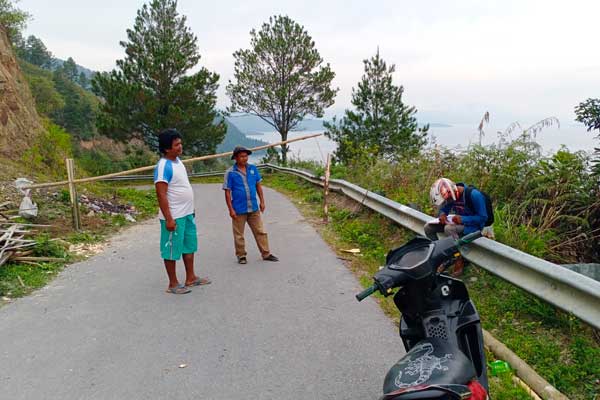 TUTUP: Warga sedang berdiri di jalan yang menuju Desa Wisata Meat Kecamatan Tampahan, Toba yang ditutup.