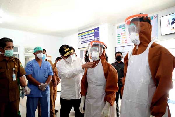KENAKAN APD Gubernur Sumatera Utara, H. Edy Rahmayadi, memakaikan Alat Pelindung Diri kepada petugas medis RSUD Salak, Kabupaten Pakpak Bharat, pada kunjungan kerja terkait penanganan pandemi Covid-19, Selasa (21/4).