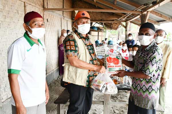 SERAHKAN: Ketua Gugus tugas Covid-19 Sergai yang merupakan Bupati Sergai Ir H Soekirman (kiri) menyerahkan bantuan ke warga yang terdampak Covid-19, Kamis (23/4).