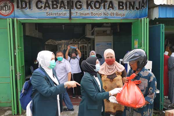 MEMBERI: Wakil Ketua IDI Cabang Kota Binjai, dr Melyana Bangun (tengah) memberikan bantuan sembako sekaligus mengedukasi masyarakat menggunakan masker kepada penarik becak bermotor. tedi/SUMUT POS