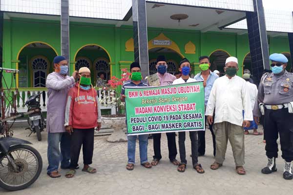 BERSAMA: Pengurus BKM Ubudiyah Pangkalan Brandan, pengusaha Konveksi Madani Langkat dan para Remaja Masjid Ubudiyah foto bersama saat memakaikan masker kepada perwakilan masyarakat di Stabat, kemarin.  ILYAS EFFENDY/ SUMUT POS