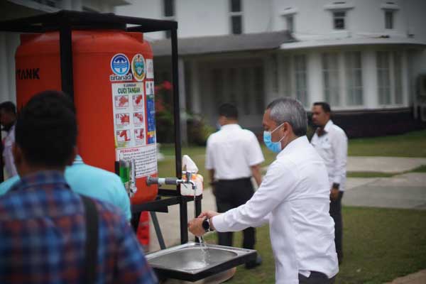 CUCI TANGAN: Dirut PDAM Tirtanadi Trisno Sumantri mencuci tangan dari tangki air yang akan disumbangkan kepada warga Kota Medan. untuk mengantisipasi penyebaran Covid-19 di halaman Rumah Dinas Gubsu, Senin (30/3).adezulfi/sumut pos