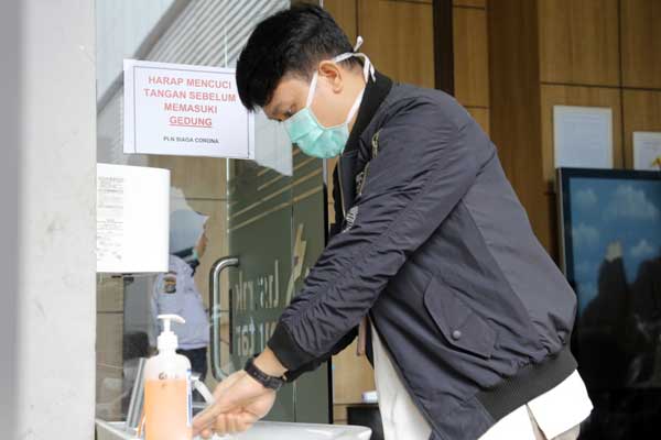 hand sanitizer: Seorang karyawan PLN Unit Induk Wilayah Sumut, mencuci tangannya dengan hand sanitizer yang disedikan di setiap pintu di Kantor PLN Unit Induk Wilayah Sumut.